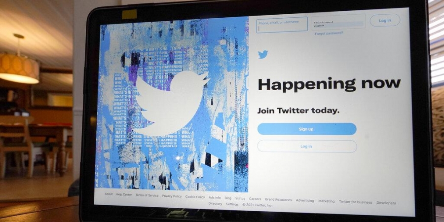 The login/sign up screen for a Twitter account is seen on a laptop computer.