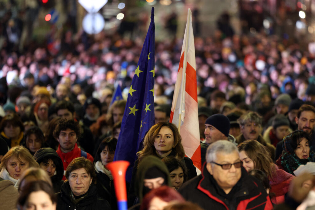 Pro-European protesters marching on Rustaveli Avenue in Tbilisi, Georgia, holding banners demanding EU integration and the release of jailed opposition leaders.