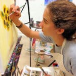 Young Indian tattoo artist creating body art in a studio with modern designs and equipment.