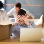 A stressed IT professional sitting with a laptop, representing mid-career job loss in India