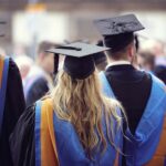 Students walking across a UK university campus, highlighting funding concerns.