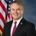 James Comer speaking at a press conference about the Jeffrey Epstein investigation, with serious expression and reporters in the background.