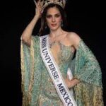 Fátima Bosch smiling and holding her crown moments after being crowned Miss Universe 2025 on stage in Thailand.